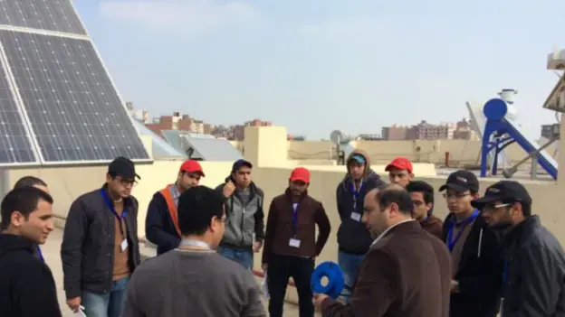 Group photo in front of the solar panels