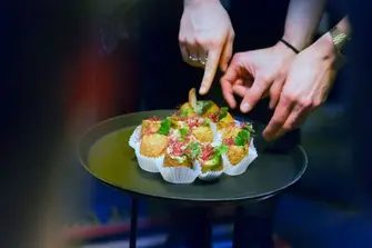 Plate with Hummus Snacks and three hands reaching out to them