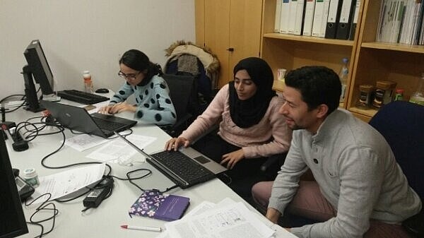 Three researchers working collectively in an office