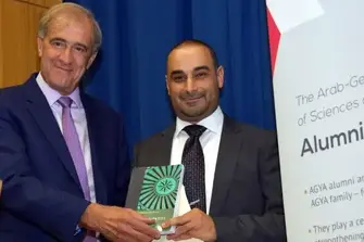 Two men holding the Book 'Insatiable Appetite' to the camera