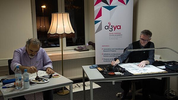 Two calligraphy artists working during the Salon Sophie Charlotte 2018