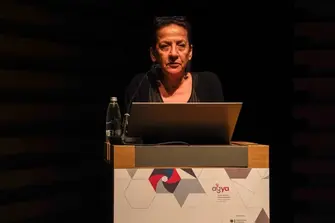 Woman on a podium with a computer in front of her